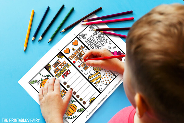 Kid coloring the Thanksgiving bookmarks