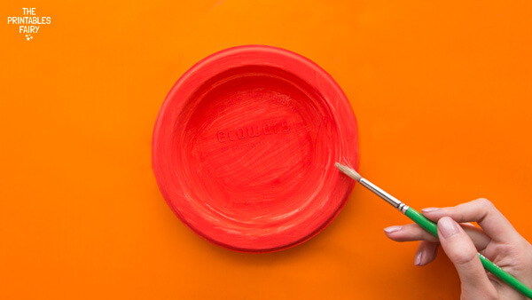 Painting red the paper plate