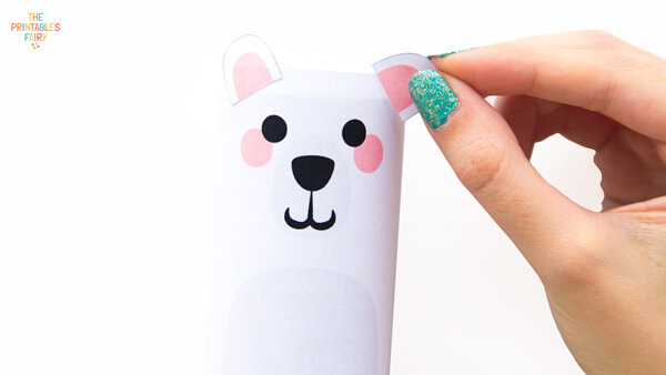 Gluing the ears on the polar bear toilet paper roll craft
