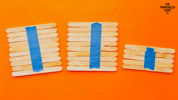 Securing the popsicle sticks with tape