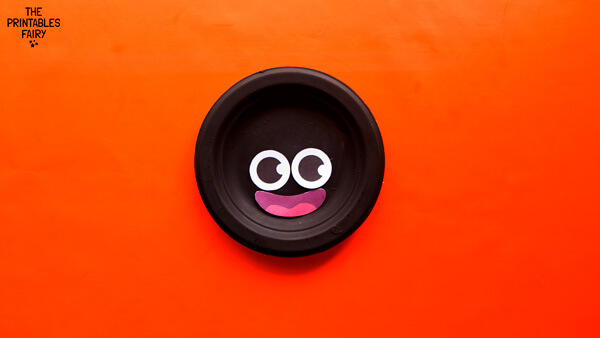 Gluing the eyes onto the paper plate